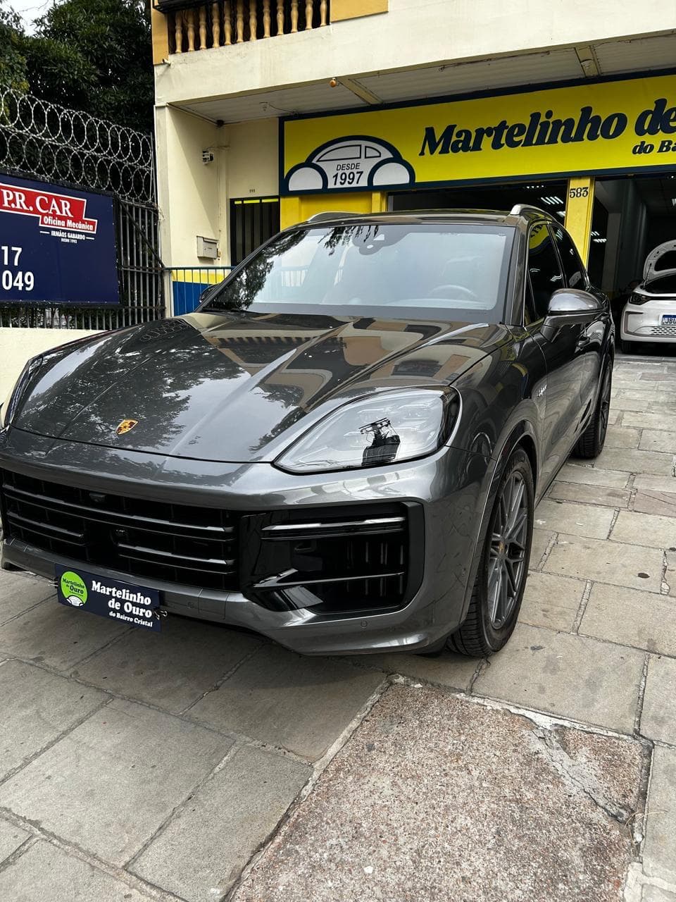 Porsche Cayenne cinza com pintura reflexiva após serviço